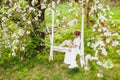 Young bride with blond hair in white negligee and stockings putting on a garter