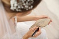 Young bride writing her single friends names on shoe indoors, closeup. Wedding superstition