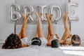 Young bridesmaids in white silk dresses on a bed in the bride's room Royalty Free Stock Photo