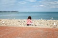 Young British woman sitting on Llandudno promenade looking out t