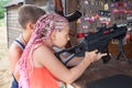 Young brother and sister aiming with pneumatic rifle in a shooting galery, side view Royalty Free Stock Photo