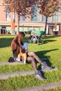 Young brown hair mother in black stockings and boots breastfeeding baby in public