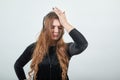 Girl brown haired in black dress over isolated white background shows emotions Royalty Free Stock Photo