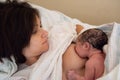 Young brown woman breastfeeding her newborn daughter. Concept of mothers