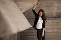 Young brunet woman standing outside in black jacket, jeans wearing hills . horizontal Royalty Free Stock Photo