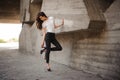 Young brunet woman standing outside in white top, jeans wearing hills . horizontal Royalty Free Stock Photo