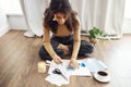 Young brunette african american woman creating her Feng Shui wish map using scissors Royalty Free Stock Photo