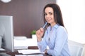 Young brunette business woman looks like a student girl working in office. Hispanic or latin american girl happy at work Royalty Free Stock Photo