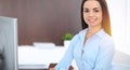 Young brunette business woman looks like a student girl working in office. Hispanic or latin american girl happy at work Royalty Free Stock Photo