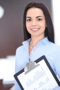 Young brunette business woman looks like a student girl working in office. Hispanic or latin american girl happy at work Royalty Free Stock Photo