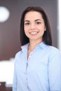 Young brunette business woman looks like a student girl working in office. Hispanic or latin american girl happy at work Royalty Free Stock Photo