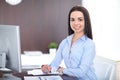 Young brunette business woman looks like a student girl working in office. Hispanic or latin american girl happy at work Royalty Free Stock Photo