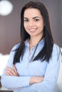 Young brunette business woman looks like a student girl working in office. Hispanic or latin american girl happy at work Royalty Free Stock Photo