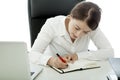 Young brunette business woman writing text in book Royalty Free Stock Photo