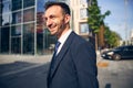 Young brunette businessman walking along street in spring Royalty Free Stock Photo