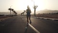 Young brunette caucasian girl jogging at tropical highway at sunrise