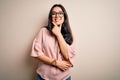 Young brunette elegant woman wearing glasses over isolated background looking confident at the camera smiling with crossed arms Royalty Free Stock Photo