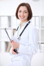 Young brunette female doctor standing with arms crossed and smiling at hospital Royalty Free Stock Photo