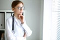 Young brunette female doctor standing with arms crossed and smiling at hospital. Physician ready to examine patient Royalty Free Stock Photo