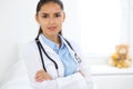 Young brunette female doctor standing and smiling at hospital Royalty Free Stock Photo