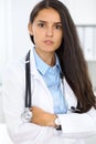 Young brunette female doctor standing and smiling at hospital Royalty Free Stock Photo