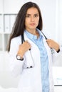 Young brunette female doctor standing and smiling at hospital Royalty Free Stock Photo