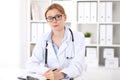 Young brunette female doctor at work in hospital. Physician ready to help. Medicine and healthcare concept Royalty Free Stock Photo