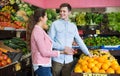 Young brunette girl and boyfriend buying citruses i Royalty Free Stock Photo