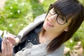 Young brunette girl with a mobile phone in park, outside Royalty Free Stock Photo