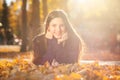 Young brunette girl in a purple sweater lies on fallen autumn leaves Royalty Free Stock Photo