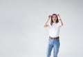 a young girl raises her glasses in surprise and looks away in surprise on a white isolated background. Royalty Free Stock Photo