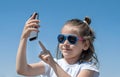 Young brunette girl in summer day enjoying the sun, making selfie portrait. Cute baby holds a mobile phone in hand and smiles Royalty Free Stock Photo