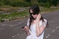 Young brunette girl walking in the stadium in a residential area and messaging on a mobile phone. Royalty Free Stock Photo