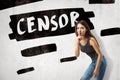 Young brunette girl wearing casual jeans and t-shirt showing silent gesture with `CENSOR` sign on white background