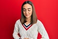 Young brunette girl wearing casual student sweater with hand on stomach because indigestion, painful illness feeling unwell