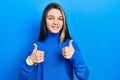 Young brunette girl wearing turtleneck sweater success sign doing positive gesture with hand, thumbs up smiling and happy Royalty Free Stock Photo