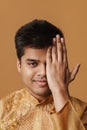 Young brunette Indian man smiling and covering his face with hand Royalty Free Stock Photo