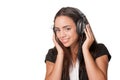 Young brunette lady listening to headphones, on white