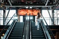 Young brunette Latina attractive woman with shopping bags on escalator in the fashion store mall.