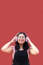 Young brunette Latina woman 17 years old with eye glasses and braces on her teeth enjoys listening to music on her headphones Royalty Free Stock Photo