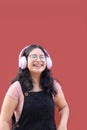 Young brunette Latina woman 17 years old with eye glasses and braces on her teeth enjoys listening to music on her headphones Royalty Free Stock Photo