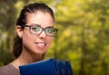 Young brunette model wearing glasses posing holding a book, intellectual concept Royalty Free Stock Photo