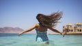 A Young Brunette\'s Spirited Leap from the Calm Waters of the Sea Royalty Free Stock Photo