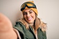 Young brunette skier woman wearing snow clothes and ski goggles make selfie by camera with a happy face standing and smiling with Royalty Free Stock Photo