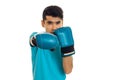 Young brunette sportsman in blue boxing gloves and uniform practicing boxing isolated on white background Royalty Free Stock Photo