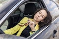 Young brunette stares out of car window, leaning against door. Royalty Free Stock Photo