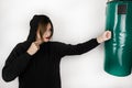 Young brunette strong woman exercising hitting boxing bag on isolated on white background