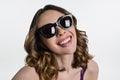 Young brunette in sunglasses looks at camera and smiles. Royalty Free Stock Photo