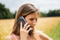 Young brunette talking on her black mobile phone while walking outside