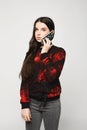 Young brunette teen girl talking on the phone, isolated on a white background Royalty Free Stock Photo